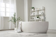 © Pixel-Shot - Interior of stylish bathroom with bathtub, shelving unit and olive tree