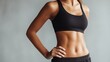 © AZ Studio - Woman showing midsection in black sports bra and shorts against gray background for fitness concept