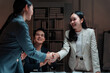 © Crystal - Business partners shaking hands at a meeting, confirming agreement and celebrating partnership, with approving colleagues present