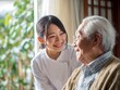 © Jumpei - 明るい室内で笑顔の介護士の女性にケアされながら穏やかに微笑む高齢者男性の接写写真