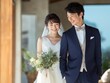 © Jumpei - タキシード姿のビジネスマンの新郎とウェディングドレスを着た笑顔の新婦が寄り添う結婚式