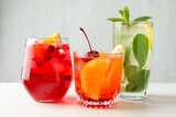 Tasty refreshing cocktails on light table, closeup