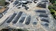 © GoAerials - Aerial drone view of quarry stockpiles with organized gravel and aggregate materials at mining site