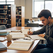 © ASHIQUE - Focused student studying in a library academic pursuit and concentration