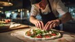 © AndiAzis - Chef preparing and adding fresh vegetables and ingredients on a handmade pizza in an italian restaurant kitchen