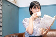 © amanaimages - カフェでコーヒーを飲みながら本を読んでいる女性