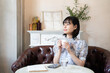 © amanaimages - カフェでコーヒーを飲みながらリラックスしている女性