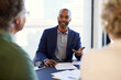 © Rido - Confident black businessman advising mature couple on finance