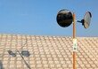 © momomi12 - 青空の下に立つオレンジ色のカーブミラーとコンクリート擁壁に映る影