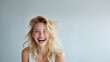 © overrust - bright studio portrait of laughing blonde woman with flowing hair, high key beauty portrait of joyful young woman on clean gray background, natural motion beauty portrait of smiling blonde woman