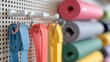 © Justlight - Medium shot of a pegboard displaying assorted resistance bands and hooks main focus on vibrant bands with cushions softly blurred in background.