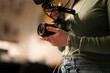 © Studio Marmellata - A person holds a camera with a microphone attached, preparing to film.