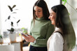 © Studio Marmellata - Two women are looking at a mobile phone together, one is smiling while the other is focused on the screen.