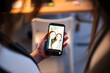 © Studio Marmellata - A person holds a smartphone displaying a selfie of two smiling young women. They are posing for a photo together.