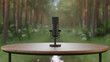 © Maxky - Professional condenser microphone on wooden table with blurred forest background