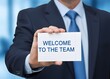 © Samoresh - The concept of the text 'Welcome to the team'. It symbolizes new employee inclusion, teamwork, cooperation and institutional welcome. A person holds a notebook in his hand.