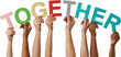 © People Stock - Multiple diverse hands hold colorful letter cutouts spelling out the word TOGETHER against a plain backdrop unity teamwork diversity inclusion collaboration community people