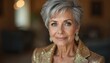 © miss irine - Glamorous mature woman with short grey hair wears sparkling gold jacket. Smiles looking at camera, wearing elegant earrings. Fashionable portrait captures ageless beauty. Luxury style, confident pose.