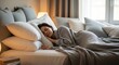 © Dara - A serene bedroom scene with a woman sleeping on a bed, covered with a gray blanket and surrounded by white pillows and a gray headboard.
