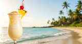 Tropical cocktail on beach with blurred background of palm trees and ocean