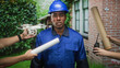 © Krakenimages.com - Man in blue hardhat and coveralls holds rolled blueprint as drone and walkie are offered near him at building; tension.