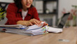© David - Woman organizing thick stack of office documents and reports with colorful binder clips on a desk in a modern corporate workspace, hands sorting paperwork and files