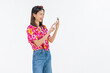 © sitthiphong - Portrait of young Asian woman in summer wearing floral shirt holding smartphone and smiling on white background.