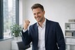 © Toshiya Takahashi - Confident Businessman Celebrating Success with Fist Pump in Modern Office