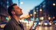 © design_fairs - Young man wearing wireless earbuds and holding smartphone on city street at dusk