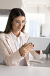 © fizkes - Confident businesswoman in suit using modern digital tablet device sits at desk in modern office, focused on screen, typing text, researching or websurfing information, prepares report, working online