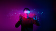 © creativestore - A man wearing virtual reality goggles in a dark room with neon lights