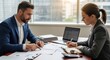 © Wattana - Two business professionals discussing financial data on a laptop in an office setting.