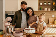 © La Famiglia - Happy family baking cake together in kitchen