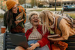 © La Famiglia - Diverse students laughing and collaborating on campus using laptop