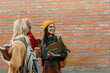 © La Famiglia - Diverse students carrying books and coffee on college campus