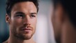 © CreativeArt - Confident young man looking at his reflection in a mirror, focusing on his face for self care and grooming