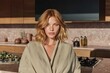 © Mariia - Portrait of Woman in Modern Luxury Kitchen Interior with Warm Light