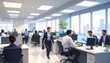 © Saro - A bustling office scene with people working at computer desks