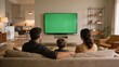 © Firmana - Family watching television with green screen display ready for content replacement, perfect for advertising and broadcast mockups