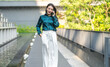 © Art_Photo - Happy young asian businesswoman talking on smartphone standing outdoor modern green office building, Confident freelancer, corporate lifestyle, mobile communication and business network concept