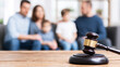 © Bonsales - Judge's gavel on a wooden table foregrounding a blurry family, representing family law, divorce, and custody issues
