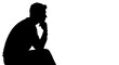 © Jujun - Silhouette of a man sitting and thinking, deep in thought, contemplative pose