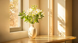 Lilienstrauß in weißer Vase auf Fensterbank im warmen Sonnenlicht