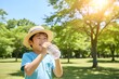 © snow-aiai - 夏の公園で帽子をかぶり水分補給をする男の子の熱中症対策イメージ（AI生成）