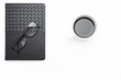 © Nordic Stock Studio - Minimal workspace with black notebook, eyeglasses and coffee cup on clean background