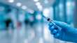 © Nikname - A hand wearing blue gloves is holding a syringe with a needle