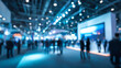 © CStock - A blurred view of a busy trade show with people networking and discussing innovations in a modern exhibition space.