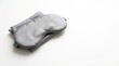 © 24DIY - Smooth gray satin sleep mask rests on neatly folded matching fabric against a clean white background