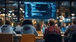 © Azzahra - Students in classroom facing large screen displaying code, working on laptops
