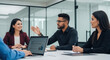 © Genowefa - Young male team leader ceo businessman having strategy planning discussion collaboration with employees sitting at office workplace desk. Group of professional business people discussing work project